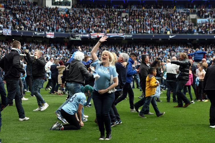 Manchester City fans on football pitch